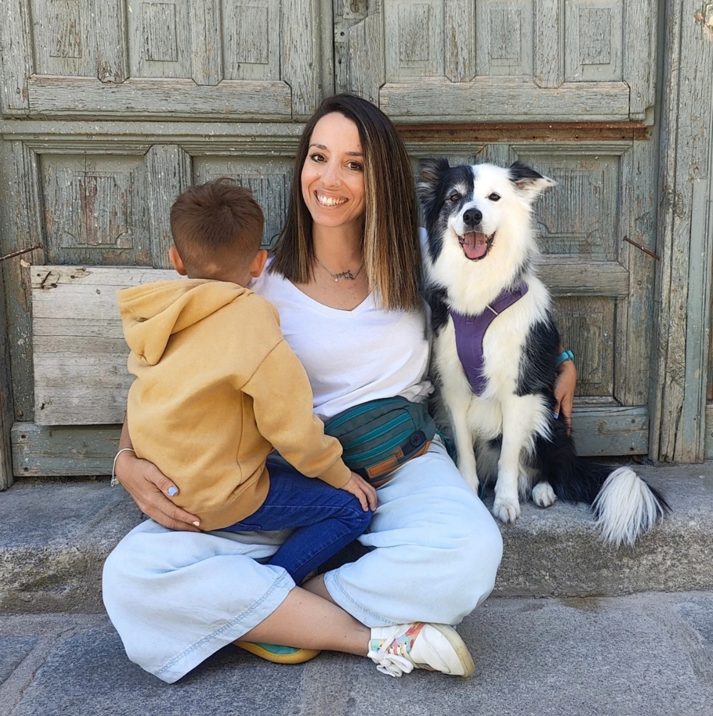 Tamara sentada con su peque y su perra